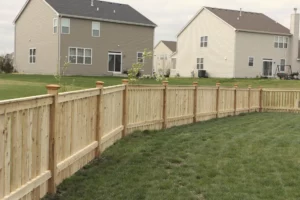 spaced wood fence wrapping around a backyard