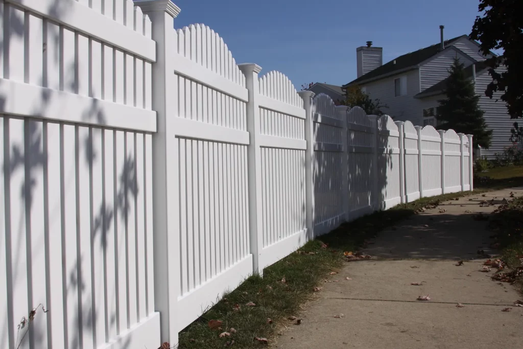 vinyl spaced fence running alongside a sidewalk