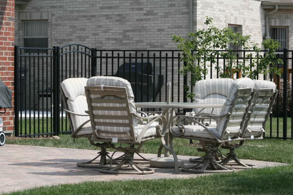 set of outdoor patio furniture within black aluminum fence