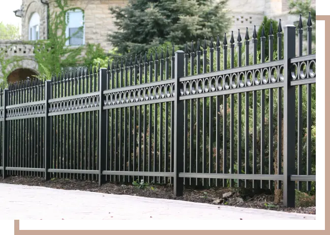 black aluminum fence in front of stone house