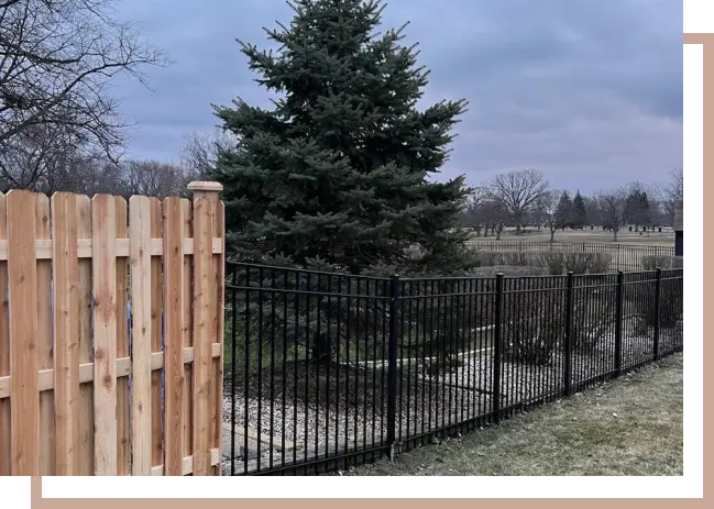 a wooden cedar fence meeting an aluminum fence