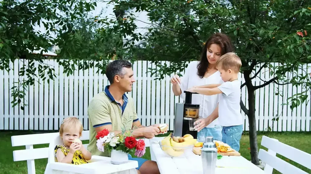 Family enjoying meal outside in fenced in backyard