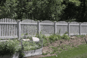 spaced vinyl fence with trees in the backyard