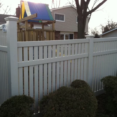 spaced vinyl fence wrapping around a background with a playset
