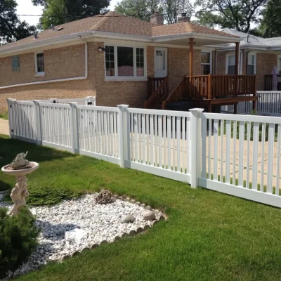 spaced vinyl fence around a house and driveway