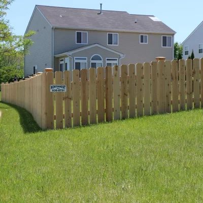 spaced wood fence wrapping around a backyard