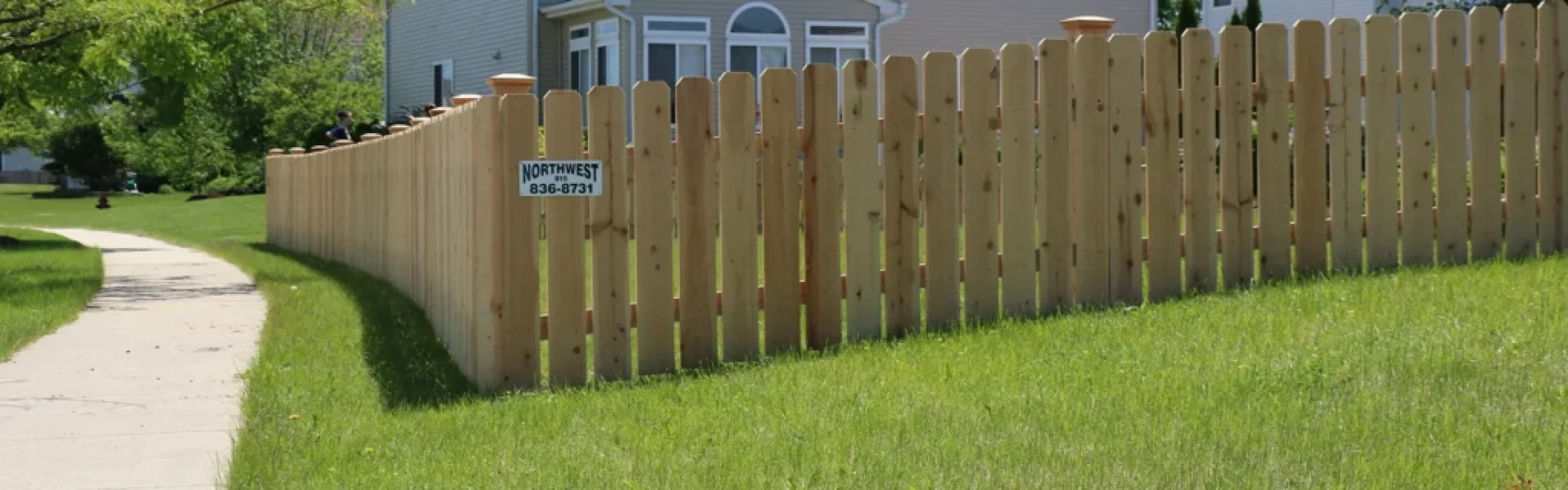 spaced wood fence wrapping around a backyard