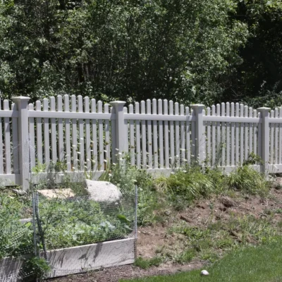 spaced vinyl fence with trees in the backyard